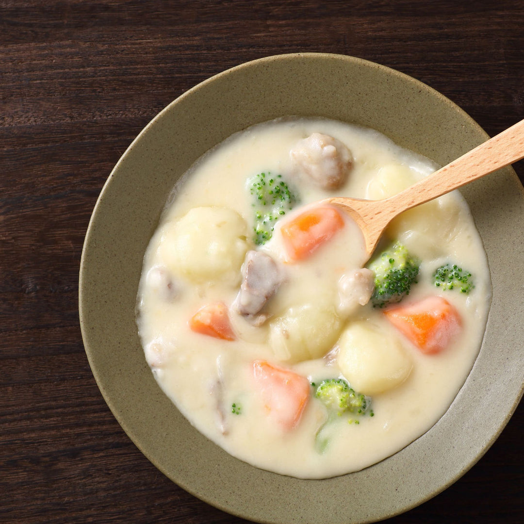 A bowl of soup with a wooden spoon and S&B Tasty Creamy Stew Mix on the shelf-stable side.