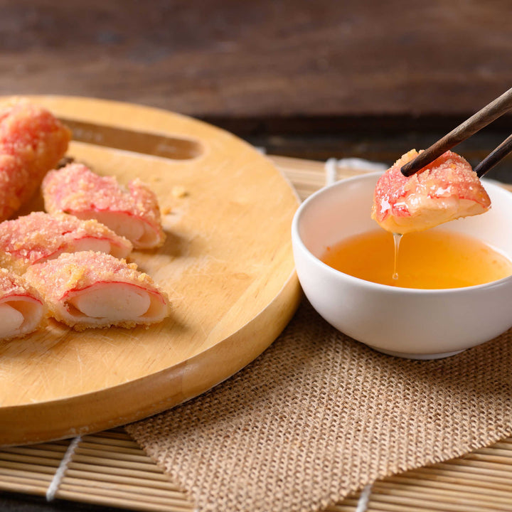 A bowl of Kibun Kanikama Imitation Crab Stick with chopsticks and a bowl of sauce.
