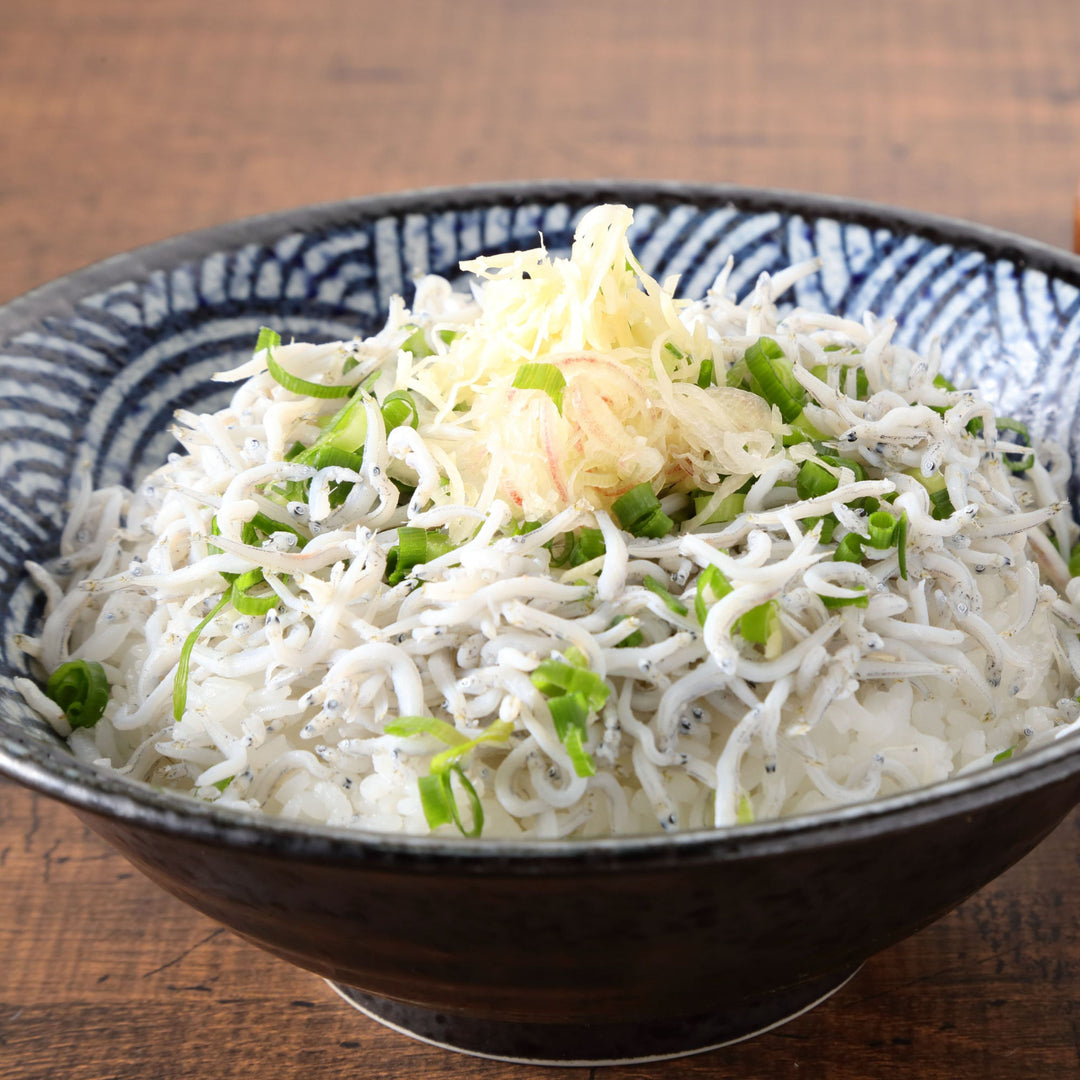 A bowl of Bokksu Tinned Shirasu Anchovies with Black Pepper and Basil-Infused Oil, noodles and green onions.