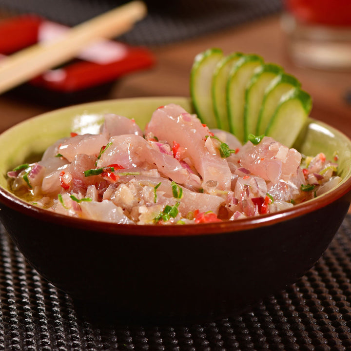 A bowl of Kyokuyo Sashimi-Grade Wild Albacore Tuna Loin (1 lb) with cucumbers and chopsticks.