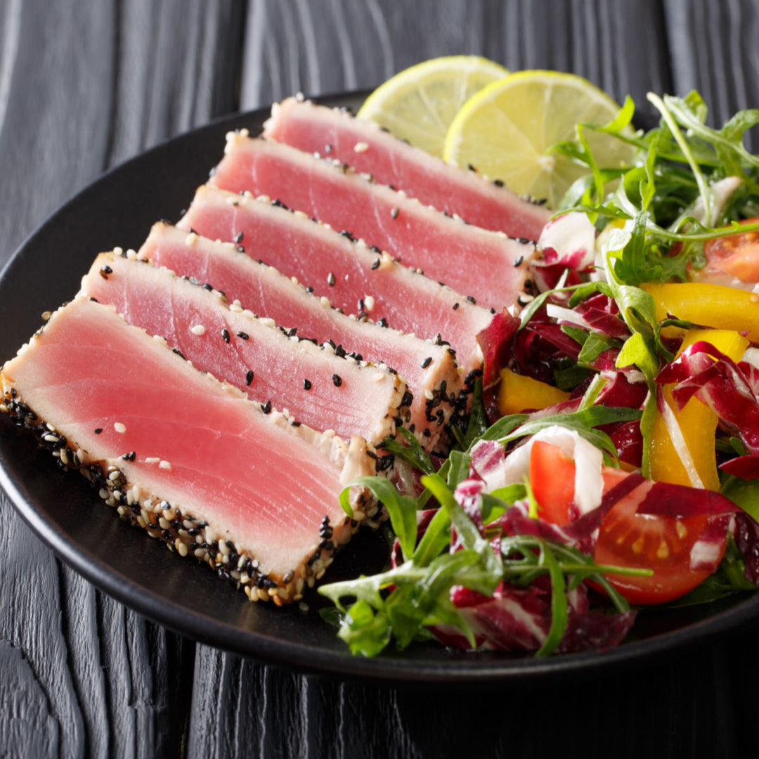 Sashimi-Grade Yellowfin Tuna (1 lb) from Sea Delight, sliced on a plate with a salad.
