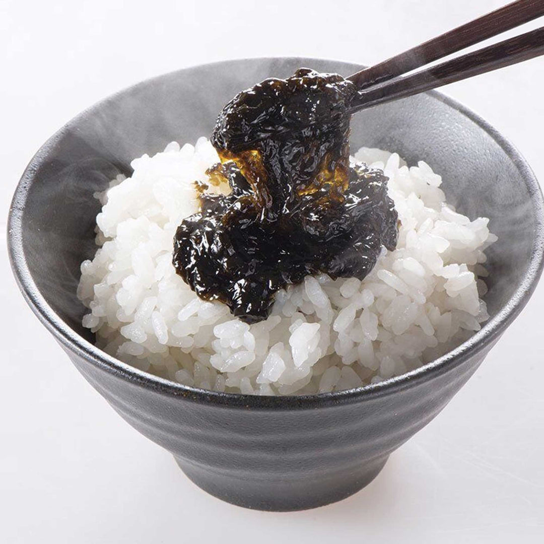 A bowl of rice with Kuze Fuku Nori Seaweed Spread and a spoon and chopsticks.
