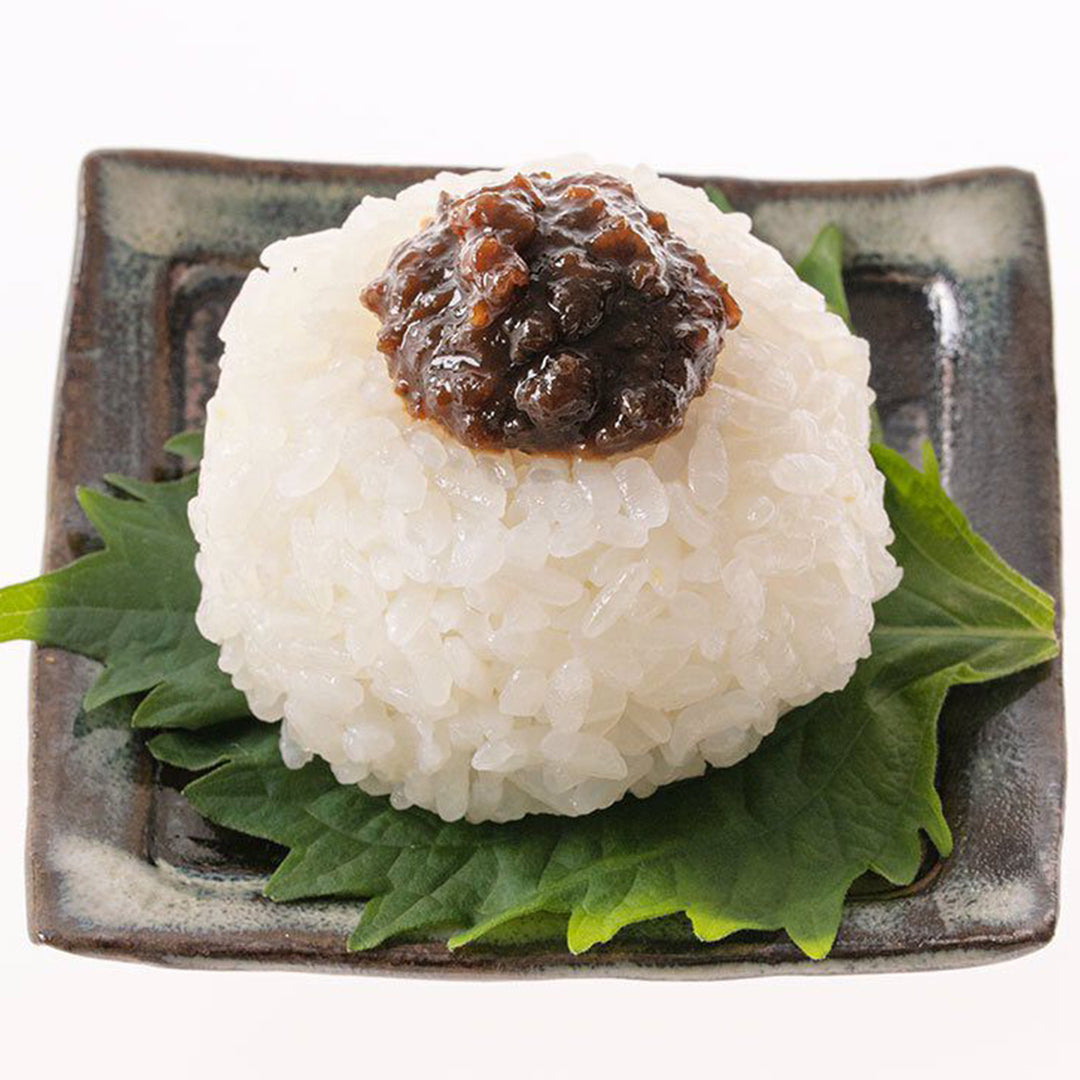 A square plate with Kuze Fuku Shiso Miso Rice Topping and a sauce on it.