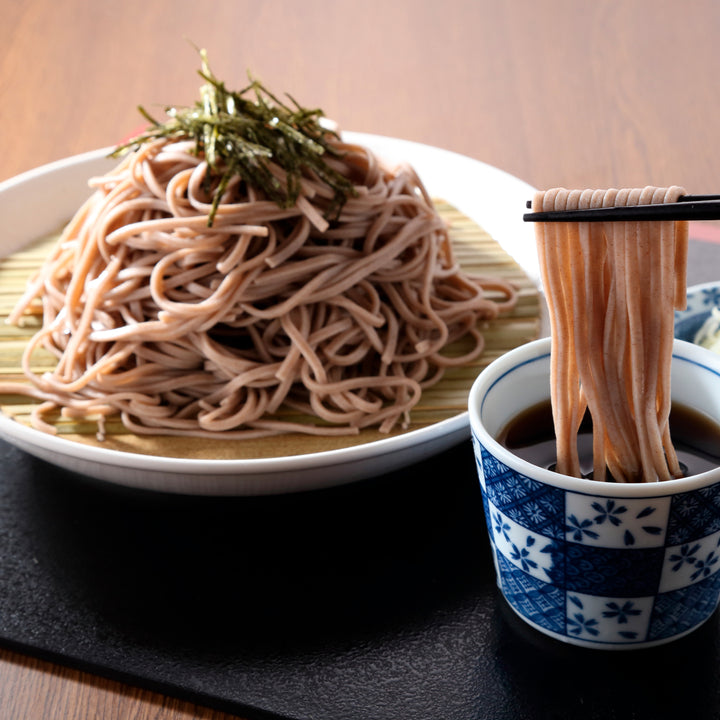 A bowl of Hakubaku Organic Soba Noodles and chopsticks on a table.