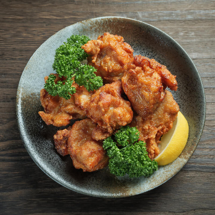 J-Basket Fried chicken on a plate with lemon and parsley.